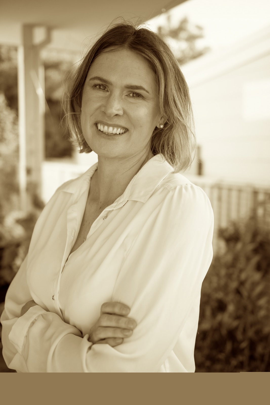 Dr Marieke Ledingham smiling, standing outside with arms folded